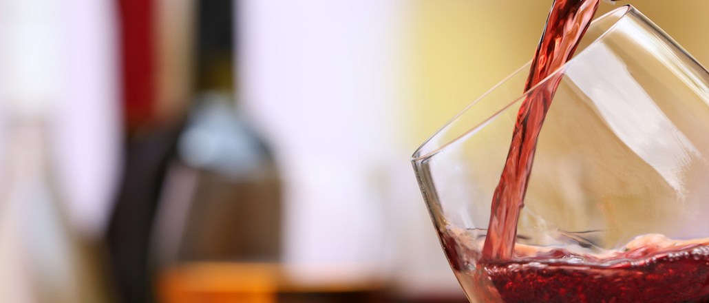 Red wine pouring into wine glass, close-up